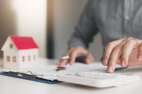 Home agents are using a calculator to calculate the loan period each month for the customer.